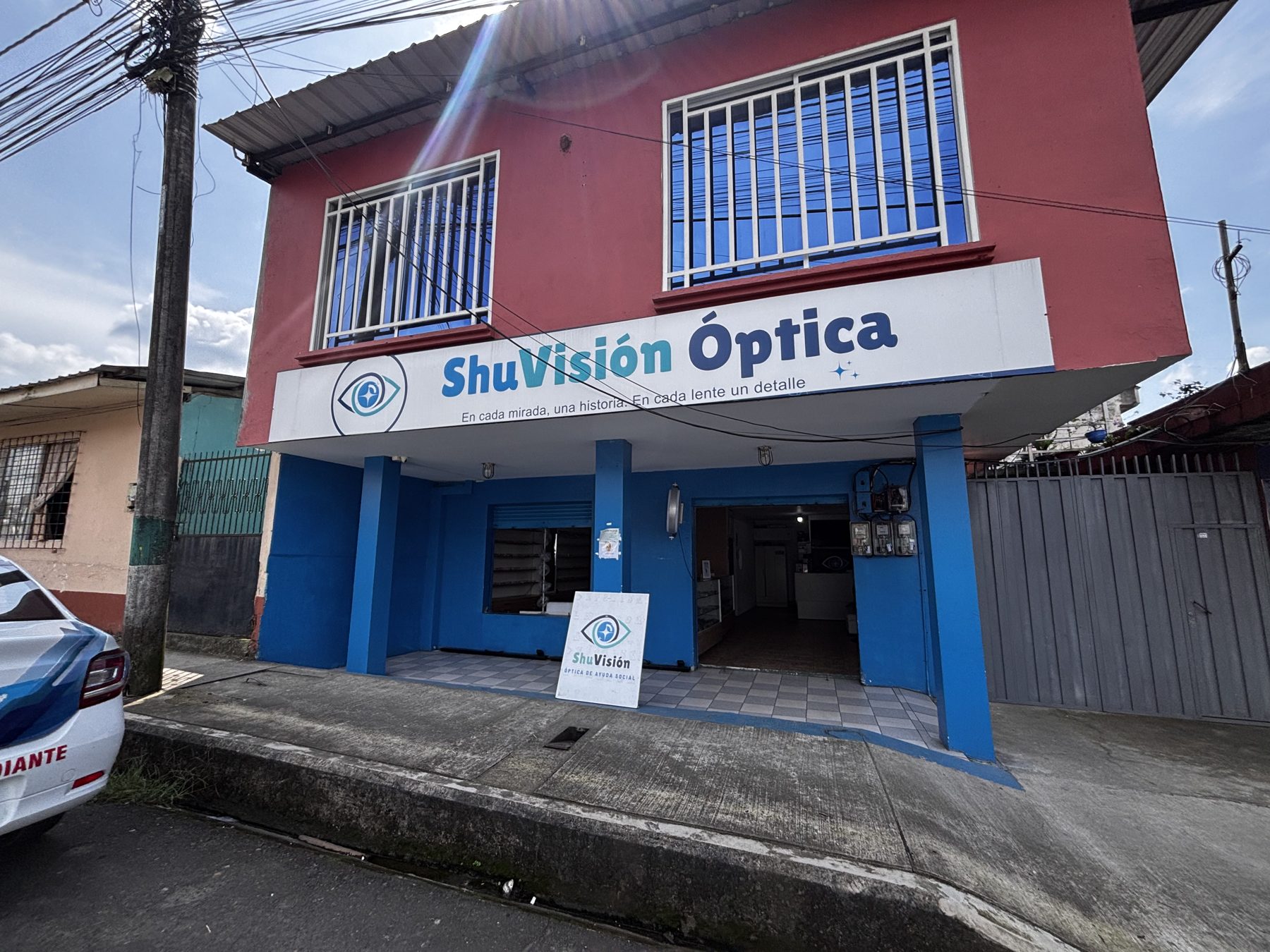 Fachada de ShuVisión Óptica en Shushufindi, con el rótulo azul y blanco sobre la entrada